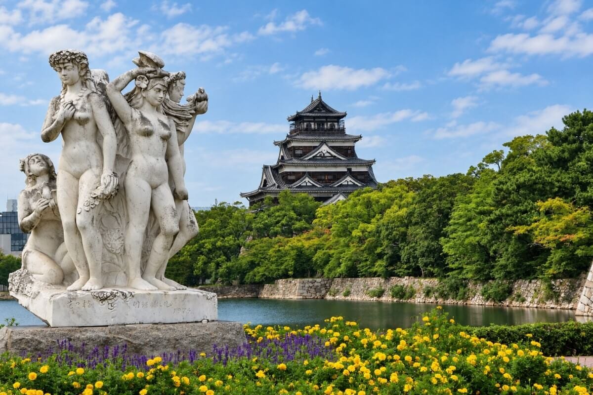 Statue and flower garden near Hiroshima Castle with the castle in the background